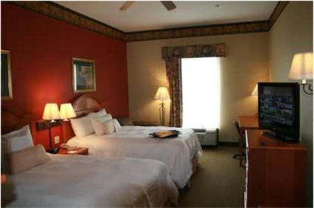 a hotel room with two beds and a flat screen tv at Hampton Inn Laplace in Laplace