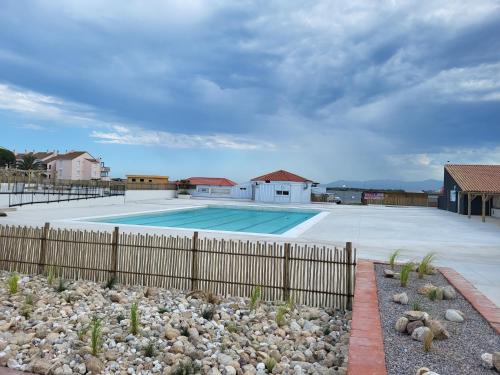 une piscine entourée d'une clôture dans l'établissement La Coudalere - F2 avec WiFi - Vue sur Sunset - Piscine chauffée, au Barcarès