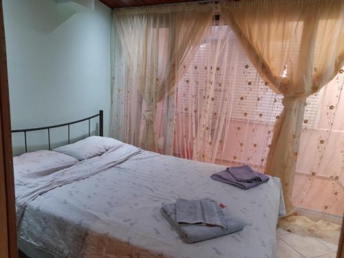 a bedroom with a bed with two towels on it at Cozy apartment in Piraeus