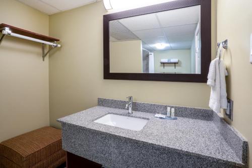 a bathroom with a sink and a mirror at Thriftlodge by Wyndham Regina North in Regina