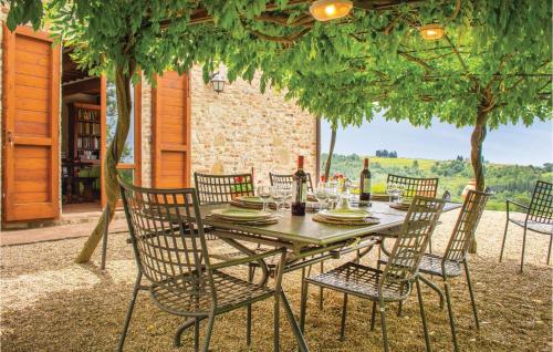 a wooden table with chairs and a table with wine bottles at Certinuzza in Luia
