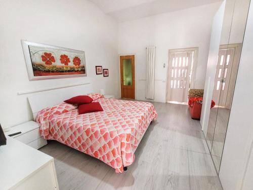 una camera bianca con letto con cuscini rossi di Nei pressi del mare a Termoli