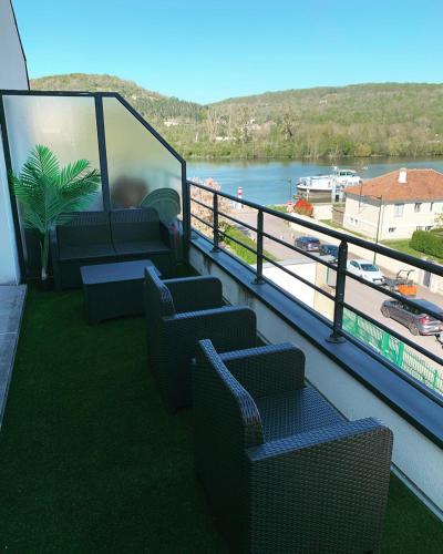 a balcony with chairs and a view of a river at Le Petit Versailles in Vernon