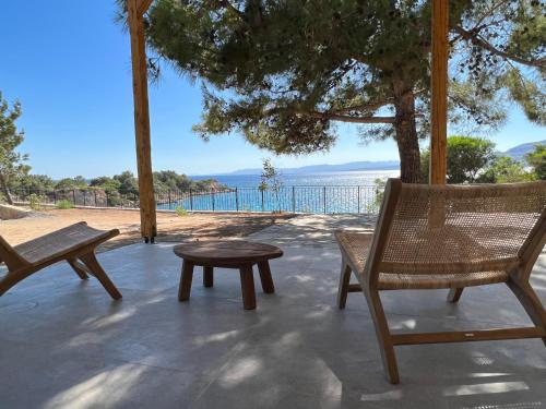 a patio with chairs and a table and a view of the ocean at Kavos beach house in Pefki Rhodes