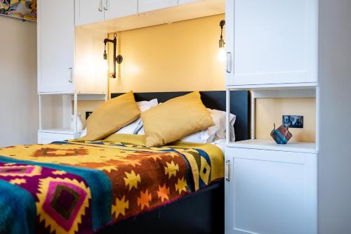 - une chambre avec un lit et une couverture colorée dans l'établissement Eakley Stables 2 - Pogo, à Newport Pagnell