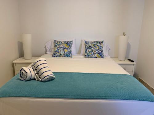 a bed with two pillows on top of it at Tu Casita en Aruba in Palm-Eagle Beach