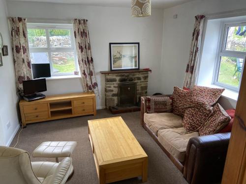 a living room with a couch and a table at Cosy 1-bedroom cottage with indoor open fireplace in Westgate