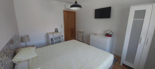 a small bedroom with a bed and a television at Apartamentos Foz O Porto in Porto