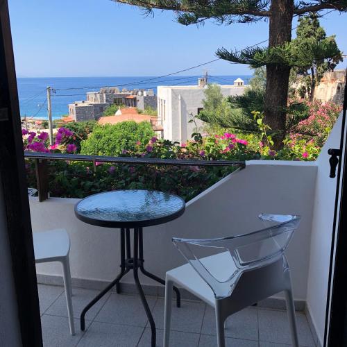 a balcony with a table and chairs and a view of the ocean at Garden House in Khóra Sfakíon