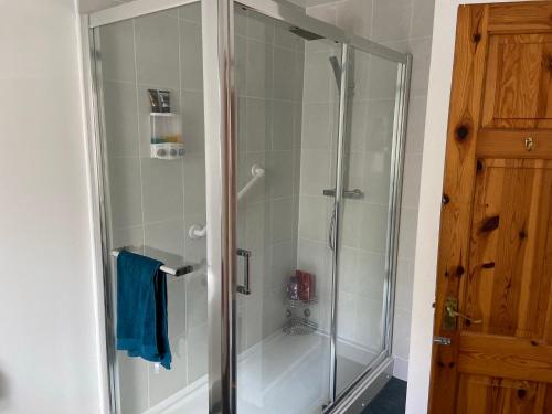 a shower with a glass door in a bathroom at Cosy 1-bedroom cottage with indoor open fireplace in Westgate