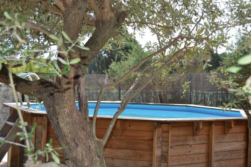 a wooden pool with a tree next to it at Juste derrière chez nous in Boulbon