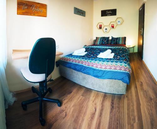 a bedroom with a bed and a desk and a chair at Universe Rooms & Apartments in Skopje