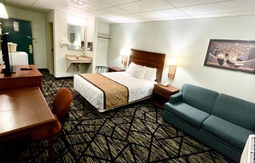 une chambre d'hôtel avec un lit et un canapé dans l'établissement Knights Inn Paxinos Elysburg, à Paxinos