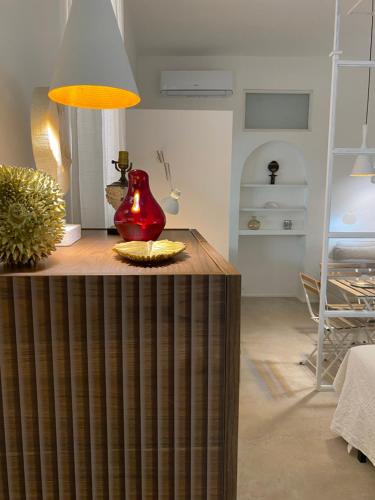 ein Wohnzimmer mit einer roten Vase auf dem Tisch in der Unterkunft Il Giardino d'Ulisse in Reggio di Calabria