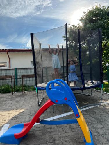 two little girls playing on a swing set at Hostel Bistrița in Eforie Sud