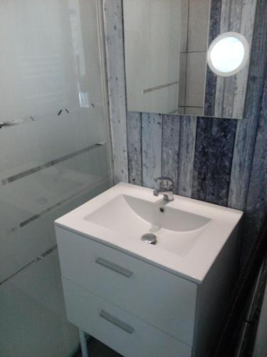 une salle de bain avec un lavabo blanc et un miroir dans l'établissement studio coconning proche de Fouras, à Saint-Laurent-de-la-Prée