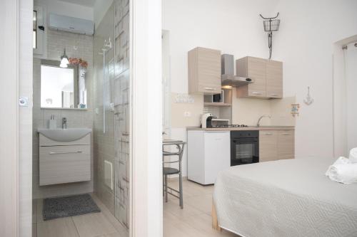 een kleine witte keuken met een bed en een wastafel bij Sweet Home in Termoli