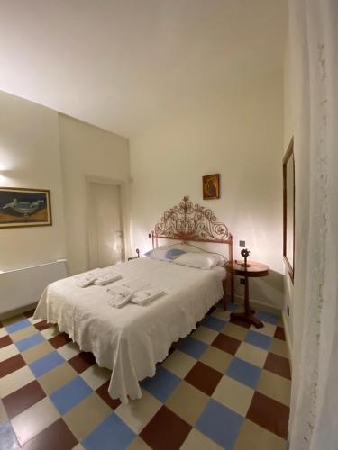 a bedroom with a bed and a checkered floor at Palazzo Vecchio Cocumola in Cocumola