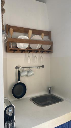un bancone della cucina con lavello, piatti e utensili di Mambo Salentino Guest House Room 16 a Matino