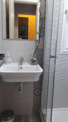 ein Bad mit einem Waschbecken und einer Dusche mit einem Spiegel in der Unterkunft FUNDADORES, Isla Cristina in Isla Cristina
