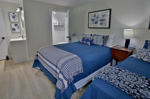 1 Schlafzimmer mit 2 Betten mit blauer und weißer Bettwäsche in der Unterkunft Gîte La Nuitée in Coaticook