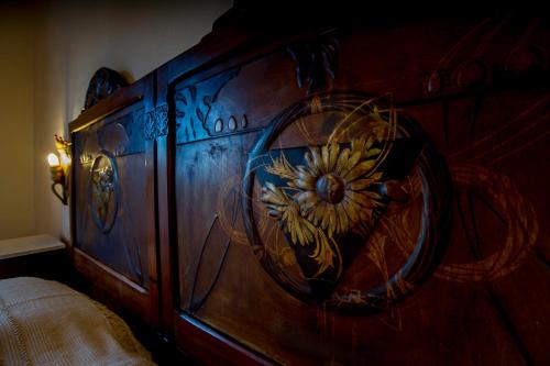 a wooden bed with a flower painted on it at Antica Dimora La Corona in San Pantaleo