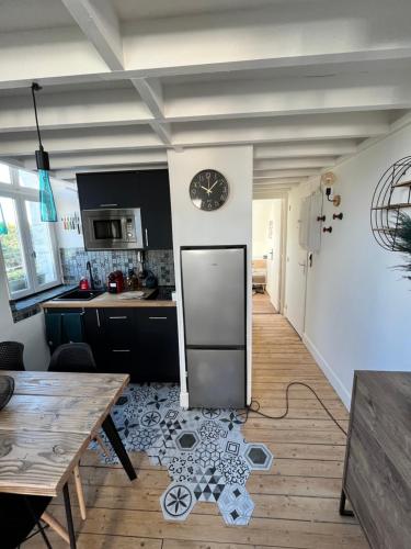 une cuisine avec une table et une horloge au mur dans l'établissement DUPLEX HYPER CENTRE - 4 pers - REFAIT A NEUF, à Cabourg
