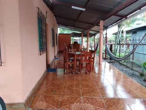 a dining room with a table and chairs on a porch at Hostal Bullshark in Cuatro Esquinas