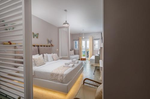 a white bedroom with a bed and a living room at Blue Bay Resort Village in Batsi