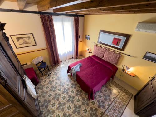 a bedroom with a purple bed and a window at Sicilia Ovest - Domus Mariae Charming Apartments with Balcony in Castellammare del Golfo