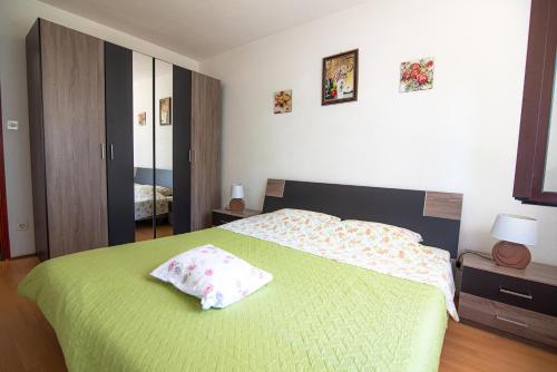 ein Schlafzimmer mit einem grünen Bett und einem Kissen darauf in der Unterkunft Apartment Igor No.2 - Free parking - Ika, Opatija in Ika