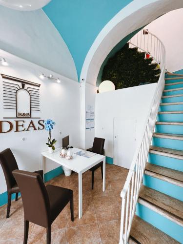 a room with a table and chairs and stairs at DEAS B&B in Trani
