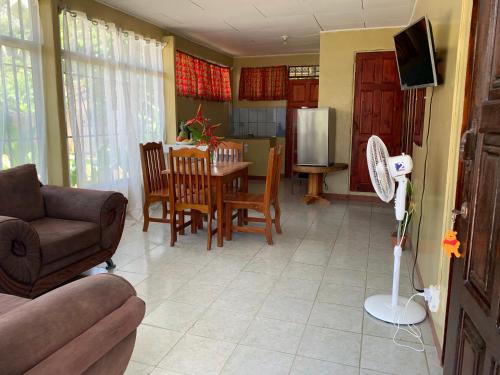 a living room with a couch and a table with chairs at Blue House with Air-Conditioning in Puerto Jiménez