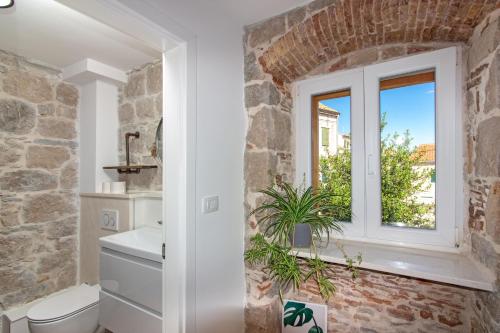 a bathroom with a stone wall and a window at Maki Stone House - Parking on request ! in Split