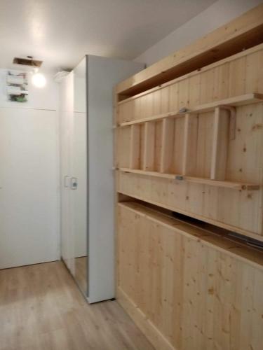 une chambre avec des étagères en bois sur le mur dans l'établissement Tignes - Charmant studio pour 2-3 personnes proche des pistes, à Tignes