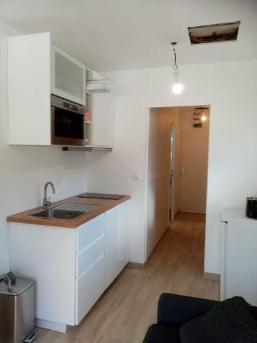 une cuisine avec des armoires blanches et un comptoir dans l'établissement Tignes - Charmant studio pour 2-3 personnes proche des pistes, à Tignes