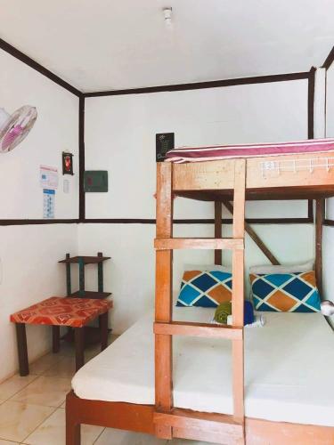 a room with two bunk beds and a table at Mama Hostel & Guest House in El Nido