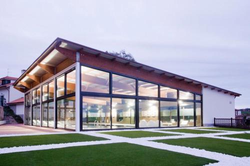 a house with large windows and green grass at La Piconera Hotel & Spa in Ribadesella