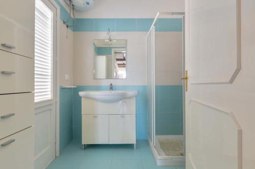 La salle de bains est pourvue d'un lavabo et d'un miroir. dans l'établissement Villa Aurora by BarbarHouse, à Porto Cesareo