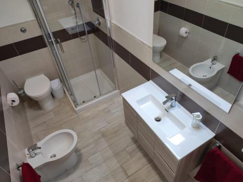 y baño con lavabo, aseo y ducha. en Apartments Villas Cagliari en Cagliari