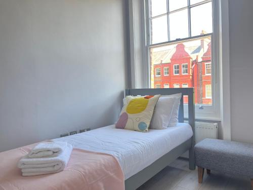 a small bedroom with a bed with a window at 2 Bedroom Apartment in South Hampstead in London