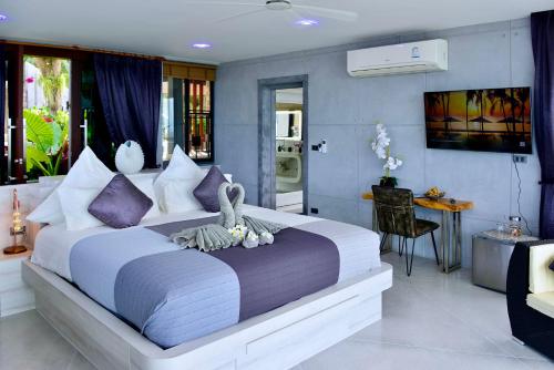 a bedroom with a large bed with purple pillows at Paradise Villa Elysium in Koh Samui