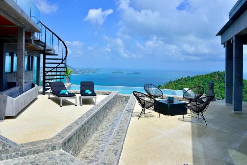 an outdoor patio with a view of the ocean at Paradise Villa Elysium - Sea View Infinity Pool with Waterfall & Jacuzzi in Koh Samui 
