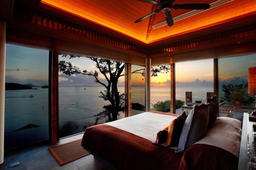 a bedroom with a bed with a view of the water at Sri Panwa Phuket Luxury Pool Villa Hotel - SHA Plus in Panwa Beach