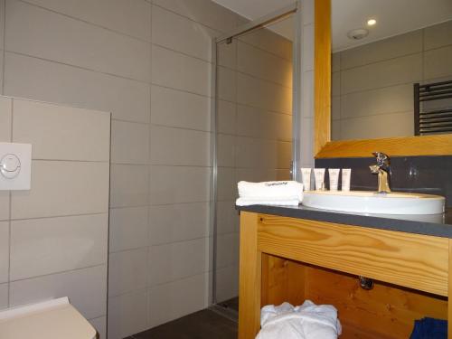 une salle de bain avec un lavabo et une douche dans l'établissement Chalet avec jacuzzi, sauna, accès direct aux pistes et Wifi - FR-1-344-744, à Saint-Martin-de-Belleville