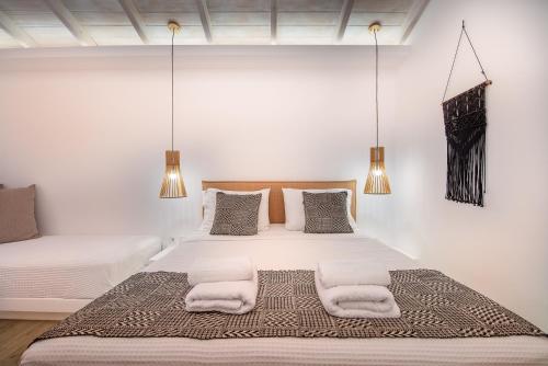 a white bedroom with two beds with towels on them at Blue Bay Resort Village in Batsi