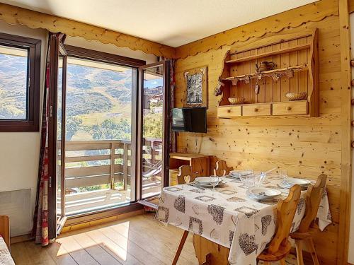 une salle à manger avec une table et une grande fenêtre dans l'établissement Appartement lumineux au pied des pistes avec balcon - 4 pers, rénové, 3 flocons, cuisine équipée - FR-1-344-977, aux Menuires