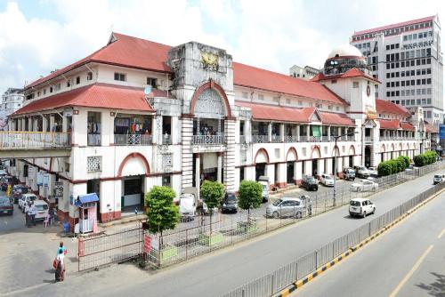 a large building with a red roof on a city street at Hotel Grand United - Ahlone Branch in Yangon
