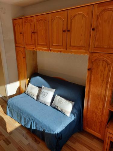 une chambre avec un lit bleu avec des armoires en bois dans l'établissement Appartement vacances à la montagne - Massif des Brasses, à Bogève