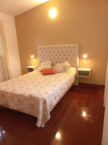 a bedroom with a large white bed with two tables at Chalet Centrico in Merlo